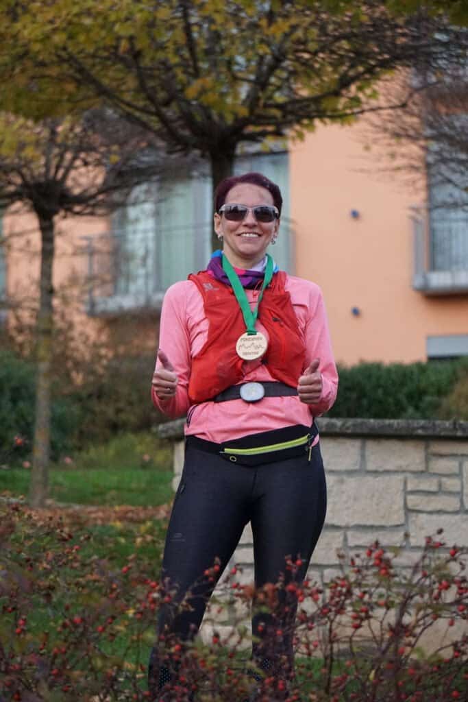 Läuferin posiert mit Medaille